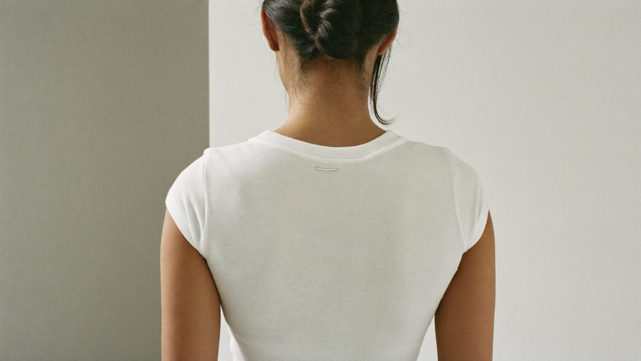 Smooth back silhouette of a woman in a fitted white t-shirt